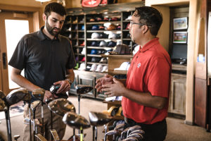 Golf club salesman talking to a customer