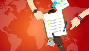 Fingers pointing to a check list on top of a global map.