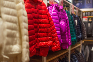 A rack of puffy jackets on a retail rack.