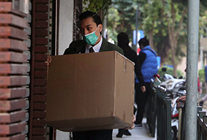 Delivery man in COVID mask holding a box