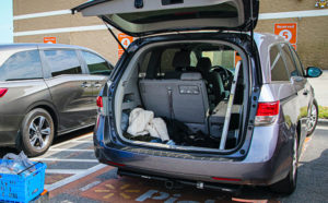 BOPIS - buy online pickup in-store. A van with an open hatch picking up purchases.