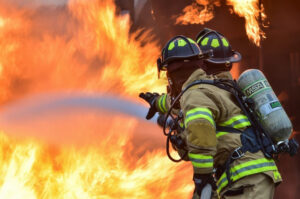 Image of firefighters hosing a structure fire.