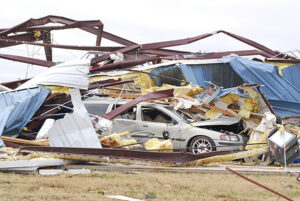 Image of car entangled in damaged commercial building