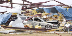 Image of car entangled in damaged commercial building