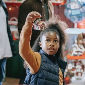 Little girl looking at a Christmas tree ornament