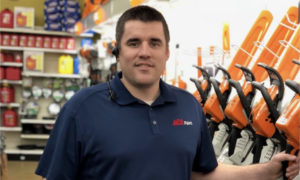 Man smiling wearing Ace polo shirt in hardware store