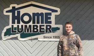 Man standing in front of sign that says "Home Lumber"