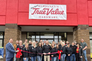 Image of the staff of McKelvey's True Value Hardware outside the store cutting a grand opening ribbon