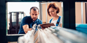 A hardware store worker helping a woman with a purchase.