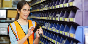 A hardware store employee scanning fasteners in a store aisle.