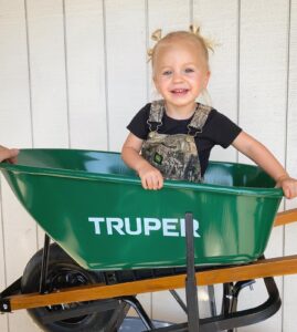 Ben and Allyssa Honeycutt's daughter in a wheelbarrow