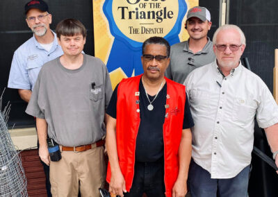 Staff of Military Hardware in front of a Best of the Triangle sign.