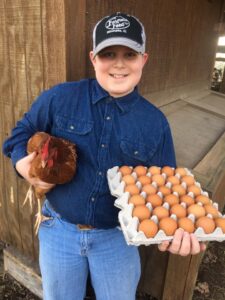4H kid with chicken and eggs