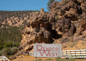 Ochoco West road sign with rock face in the background