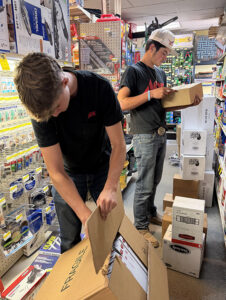 Staff at Tolmie's Ace Hardware unpackaging new inventory.