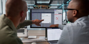 Two engineers look at Data Using Advanced Software Tools.